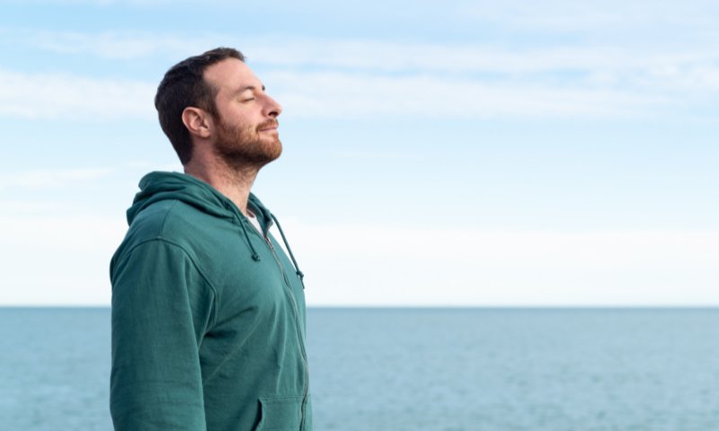 man relaxing at the beach to clear his head